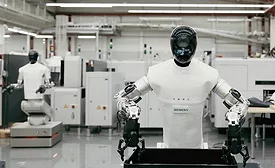 A humanoid robot with mechanical arms and cameras in its head works in a Siemens factory