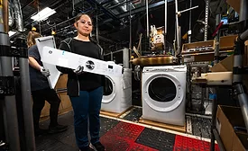 Woman at manufacturing plant holds up her work product