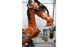 KUKA industrial robot using end-of-arm tooling to handle heavy engine component in automated manufacturing cell