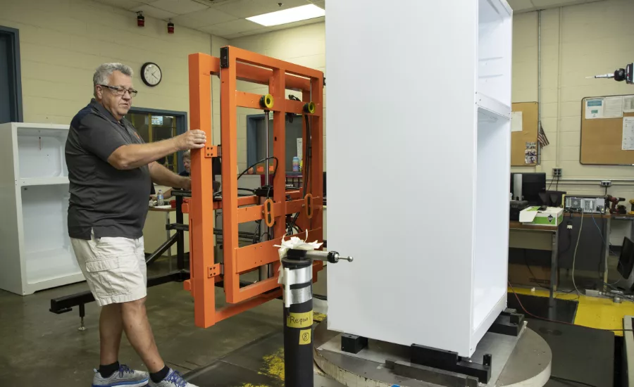 Refrigerator Manufacturing Worker Handling Internal Components Production Line