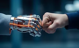 Human worker fist-bumping an AI-powered robot, symbolizing collaboration between human expertise and physical AI in advanced manufacturing and autonomous robotics applications.