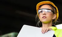 Manufacturing employees operating advanced production equipment in a modern factory as AI infrastructure investment, rising orders and increased output drive U.S. manufacturing growth.