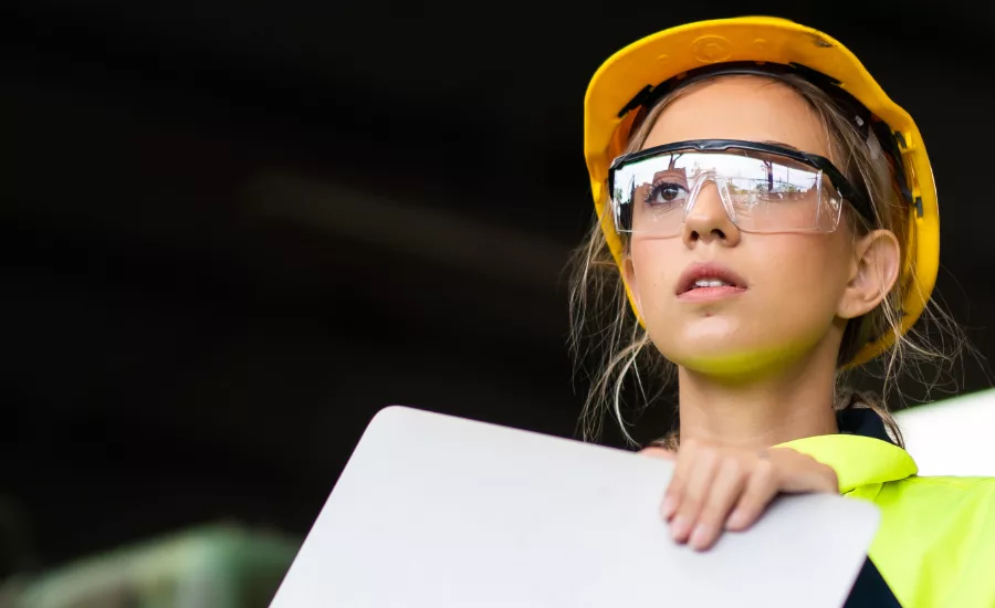 Manufacturing employees operating advanced production equipment in a modern factory as AI infrastructure investment, rising orders and increased output drive U.S. manufacturing growth.