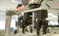 Collaborative Robot Automation for Precision Manufacturing Robotic gripper mounted on a collaborative robot arm in a manufacturing setting.