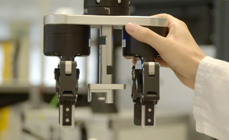 Hand adjusting a robotic gripper on a collaborative robot system.