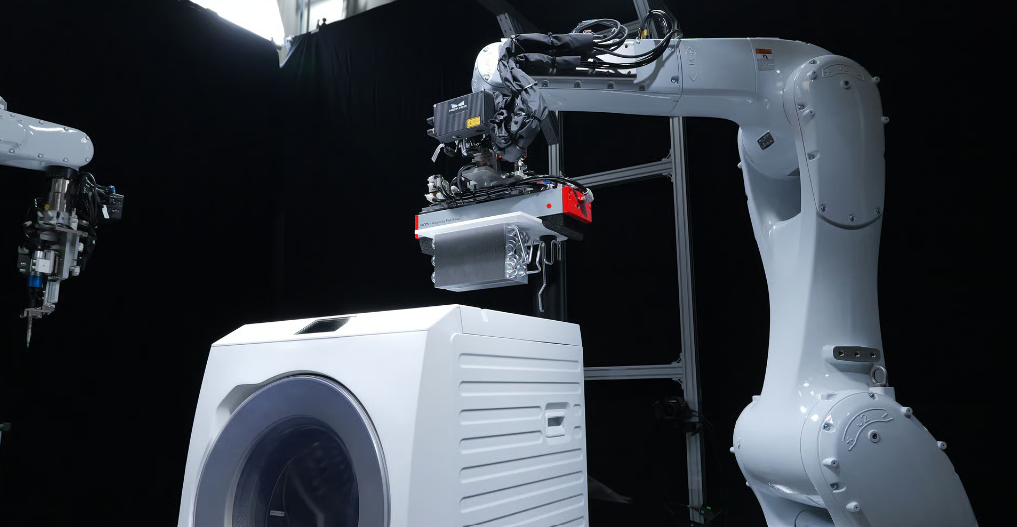 Industrial robot handling a household appliance during an automated disassembly process for recycling, inspection, or material recovery operations.