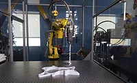 Industrial robot performing automated 3D scanning and inspection of a manufactured component on a precision measurement table.