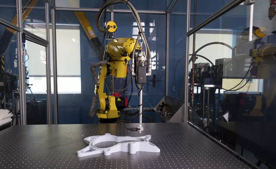Industrial robot performing automated 3D scanning and inspection of a manufactured component on a precision measurement table.