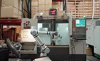 Collaborative Robot Tending a CNC Machine Collaborative robot loading parts into a CNC machining center.