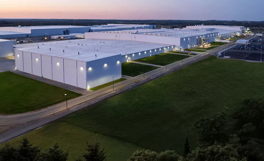 Aerial view of a large industrial warehouse and distribution complex at dusk.