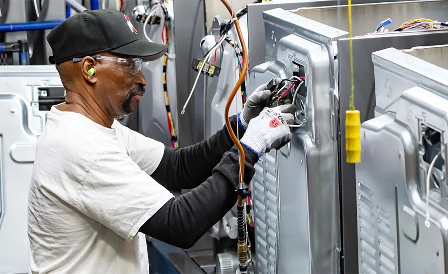 Automotive Assembly Line Installation Workers installing components on a vehicle assembly line.