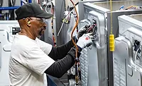Automotive Assembly Line Installation Workers installing components on a vehicle assembly line.