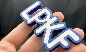 Laser-welded polymer sample with raised lettering.