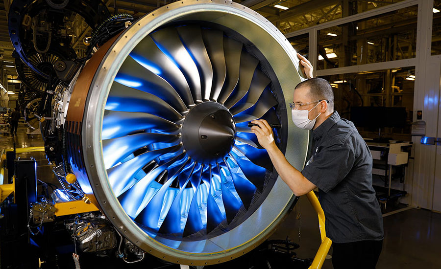 worker inspecting a jet engine