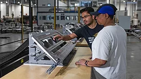 Two quality employees looking at equipment