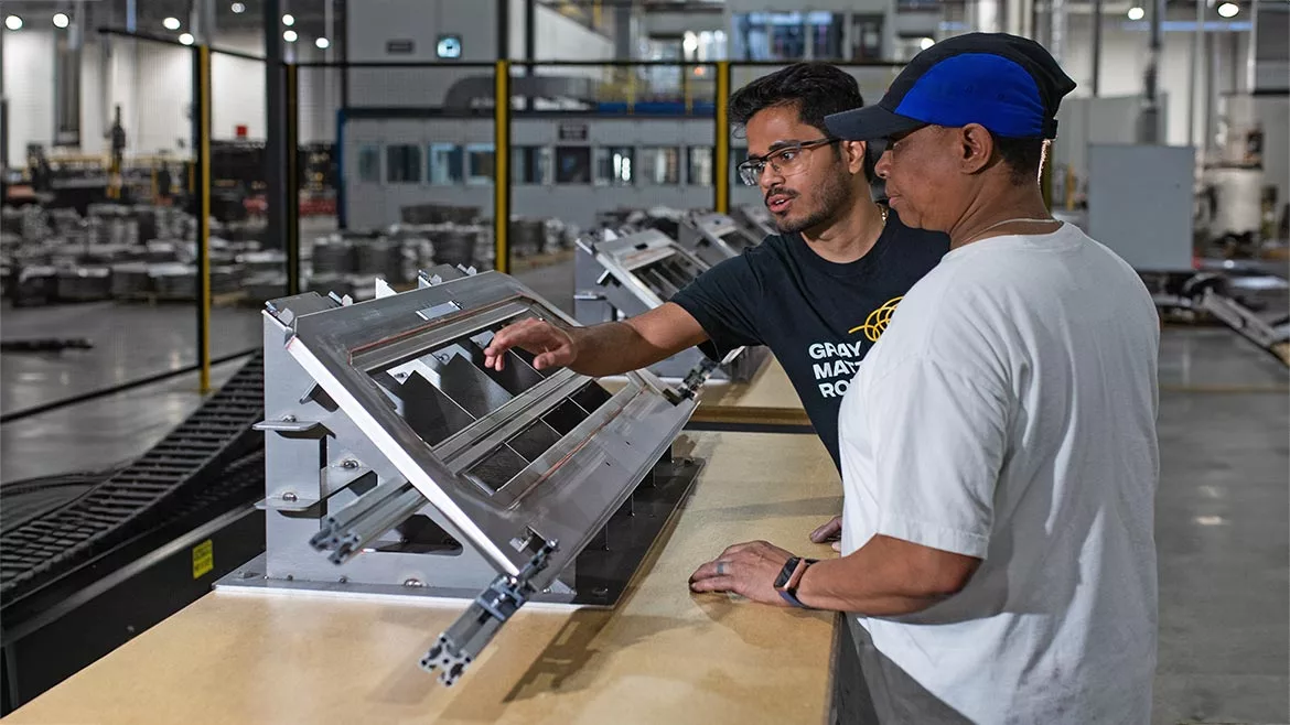 Two quality employees looking at equipment