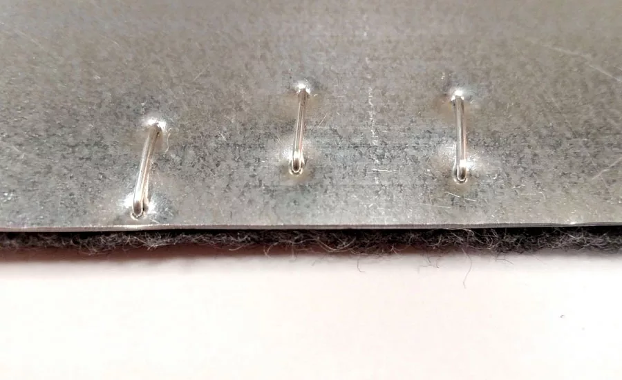 Felt stitched to metal substrate, clinched side.