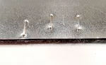 Felt stitched to metal substrate, clinched side.