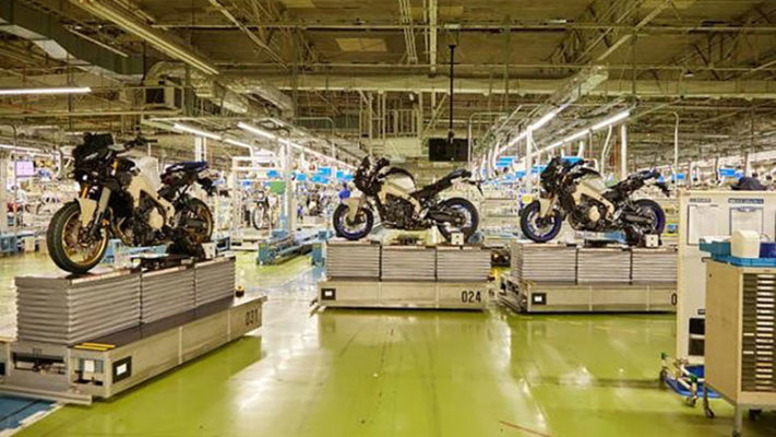 Automated guided vehicles transport motorcycles through a factory