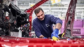 worker assembles an electric vehicle