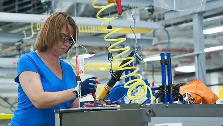 woman assembling an appliance in a factory