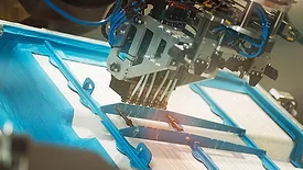 six-robot sprays hot-melt adhesive in a swirl pattern
