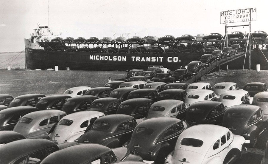 a batch of Chrysler, Dodge and Plymouth sedans are ready to be loaded onto a lake freighter