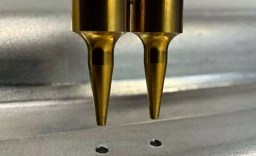 a hardened pointed tool is pressed into the top metal sheet
